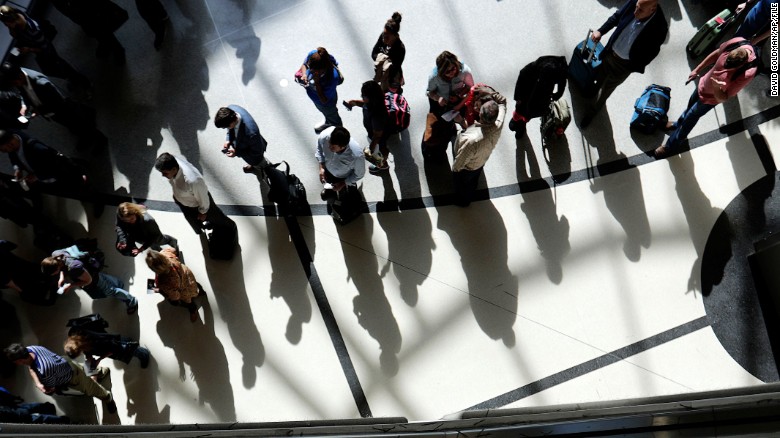 Passengers are reflected in glass as they line up to go through a security checkpoint under the atrium of the domestic passenger terminal at Hartsfield-Jackson Atlanta International Airport on Thursday, March 10, 2016, in Atlanta. On Thursday, officials announced a $6 billion expansion and renovation project at the world&#39;s busiest airport during the next 20 years. (AP Photo/David Goldman)