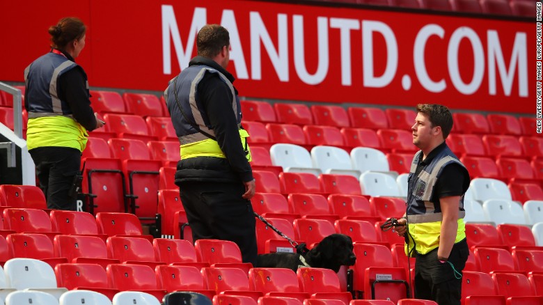 A sniffer dog patrols the Old Trafford stands.