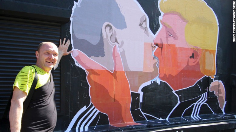 Restaurant owner Dominykas Ceckauskas pose next to a mural on the wall of his establishment depicting US Presidential hopeful Donald Trump and Russian President Vladimir Putin greeting each other with a kiss in the Lithuanian capital Vilnius on May 13, 2016. 