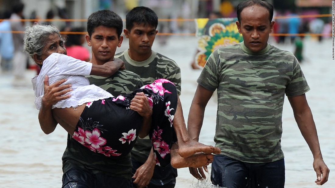 A member of a Sri Lankan Army rescue team carries an elderly woman to safety through floodwaters in Colombo on Wednesday, May 17, 2016. At least 19 were killed in the flooding or flood-triggered landslides. Army and navy teams have been deployed to rescue people marooned by the flooding. 