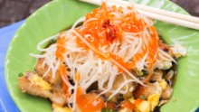 Ho Chi Minh City's favorite streetside snack. Bot chien features chunks of rice flour dough that have fried in a large wok until crispy. Then, an egg is broken into the mix. It's served with slices of papaya, shallots and green onions.