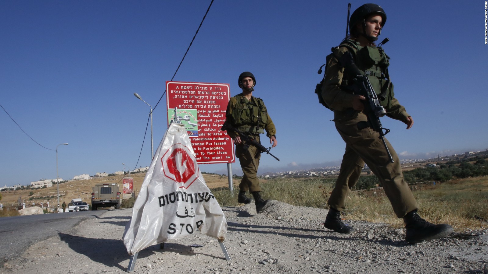 Israeli soldiers walk near a temporary checkpoint at the entrance of the Palestinian village of Yatta in the occupied West Bank on June 9,2016 after the army entered the village in search for clues leading to an attack the previous night in the Israeli city of Tel Aviv in which four people were killed and 16 others wounded.
The two Palestinians assailants who carried out the attack came from Yatta, according to Israeli authorities. Israel said it had suspended entry permits for 83,000 Palestinians during the holy Muslim month of Ramadan following the shooting attack.
/ AFP / HAZEM BADER (Photo credit should read HAZEM BADER/AFP/Getty Images)