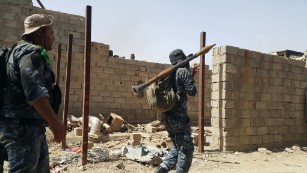 Troops from the Iraqi Federal Police engage in a battle with ISIS militants in Falluja