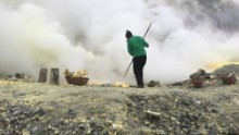 Indonesian men use long metal poles to break off chunks of yellow crust -- sulfur -- from the crater floor.