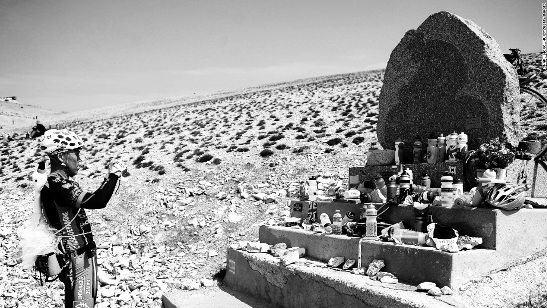 A spectator takes a photo of the Tommy Simpson memorial on Mont Ventoux. British cyclist Simpson died on the mountain during the 1967 Tour de France.