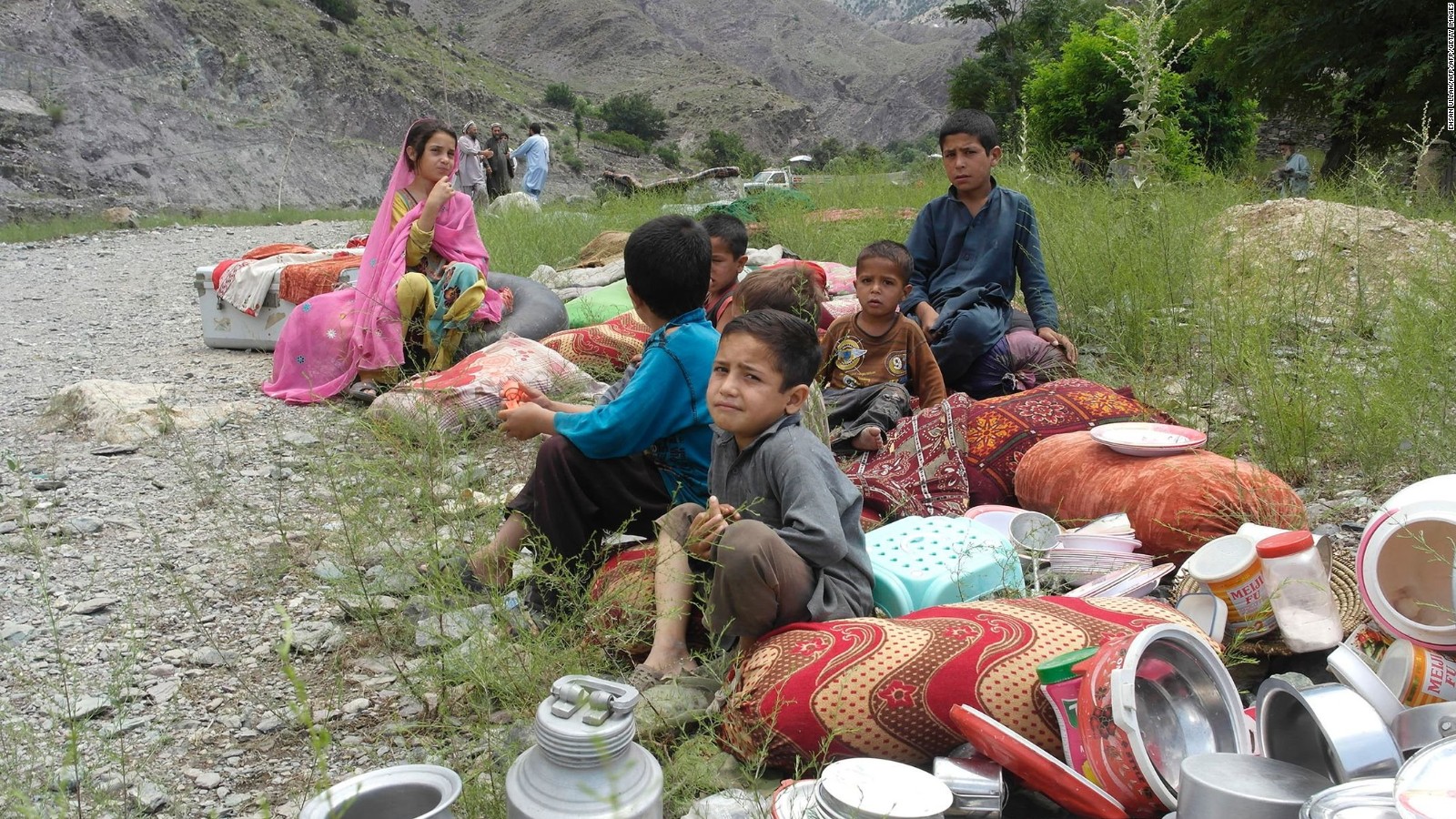 Pakistani children affected by flooding take refuge Sunday on higher ground in the village of Nagar in Chitral.