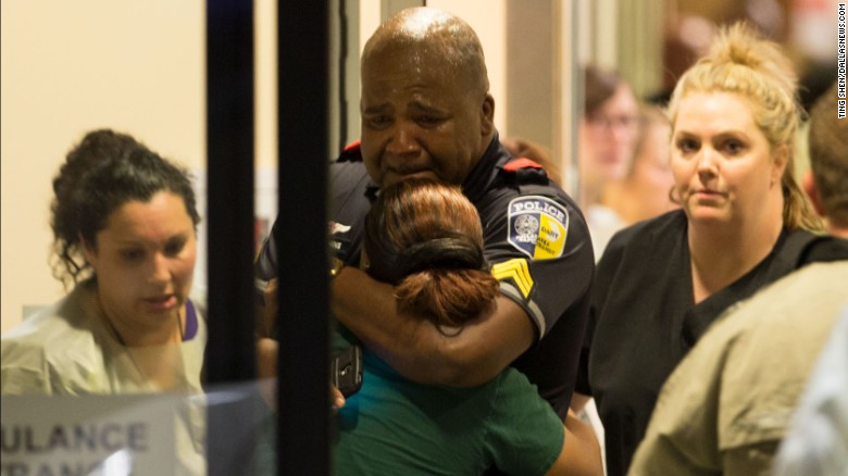 A DART (Dallas Area Rapid Transit) police officer receives comfort at Baylor University Hospital emergency room entrance on July 7, 2016 in Dallas, Texas. Dallas protestors rallied in the aftermath of the killing of Alton Sterling by police officers in Baton Rouge, La. and Philando Castile, who was killed by police less than 48 hours later in Minnesota.  (Ting Shen/The Dallas Morning News) -- MANDATORY CREDIT, NO SALES, MAGS OUT, TV OUT, INTERNET USE BY AP MEMBERS ONLY ORG XMIT: DMN1607072205371652