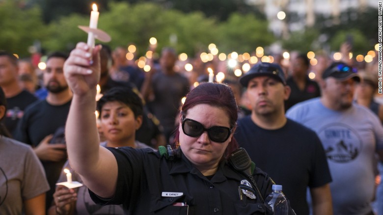 Mourners attend a Monday candlelight vigil for five officers killed last week during protests in Dallas.