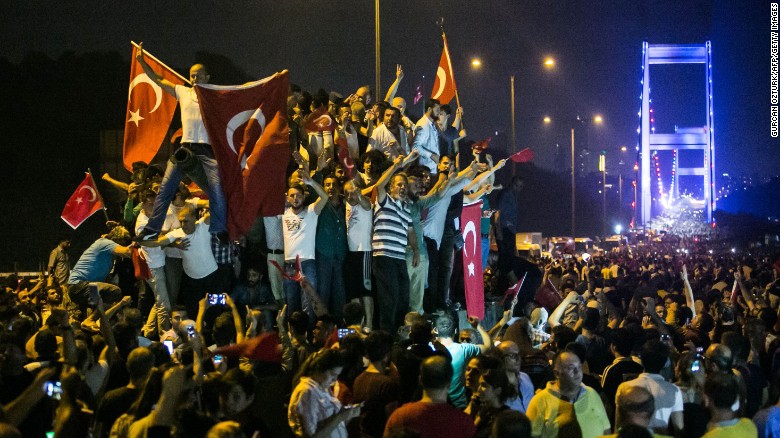 People take streets near the Fatih Sultan Mehmet bridge during clashes with military forces in Istanbul on July 16, 2016. Istanbul's bridges across the Bosphorus, the strait separating the European and Asian sides of the city, have been closed to traffic. Turkish military forces on July 16 opened fire on crowds gathered in Istanbul following a coup attempt, causing casualties, an AFP photographer said. The soldiers opened fire on grounds around the first bridge across the Bosphorus dividing Europe and Asia, said the photographer, who saw wounded people being taken to ambulances.