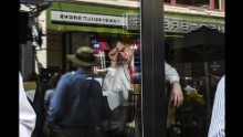A convention-goer sits inside a restaurant during lunchtime.