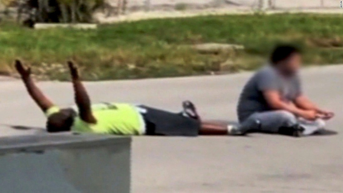 In cell phone footage, behavior therapist Charles Kinsey lies in the street with his hands in the air.