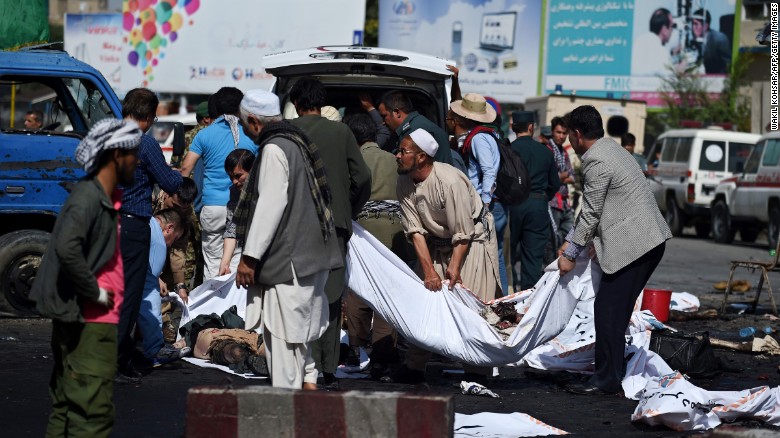 Afghan volunteers carry the bodies of victims at the scene of a suicide attack that targeted crowds of minority Shiite Hazaras during a demonstration at the Deh Mazang Circle of Kabul on Saturday, July 23. 