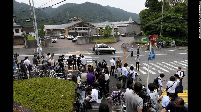 Journalists gather at the main gate of the Tsukui Yamayuri En care center