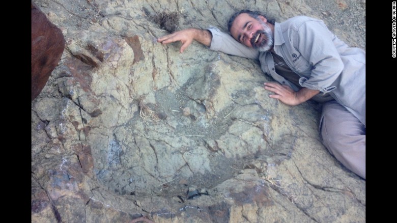 Paleontologist Sebastian Apesteguia lies next to a newly discovered dinosaur footprint in Bolivia.