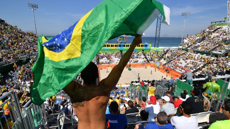 A Brazilian fan waves the national flag during the first day of the Olympic beach volleyball competition. Security checks meant long queues for those entering, and left the venue looking half empty for the early matches.