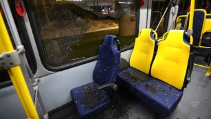 Shattered glass lies on the seats of a media bus in Rio de Janeiro, Brazil, on Tuesday, August 9.