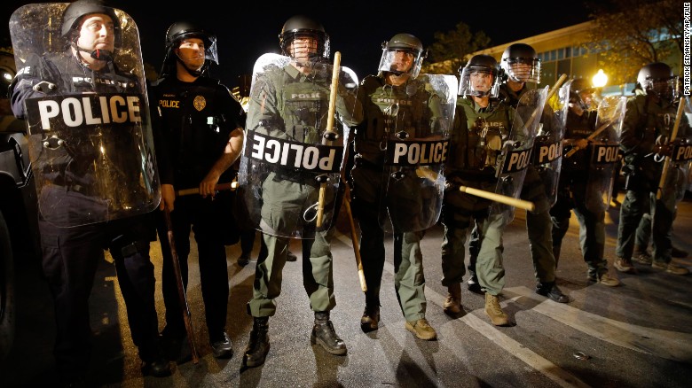 FILE - In this April 29, 2015 file photo, police stand in formation as a curfew approaches in Baltimore. Baltimore police officers routinely discriminate against blacks, repeatedly use excessive force and are not adequately held accountable for misconduct, according to a harshly critical Justice Department report being presented Wednesday, Aug. 10, 2016. (AP Photo/Patrick Semansky, File)