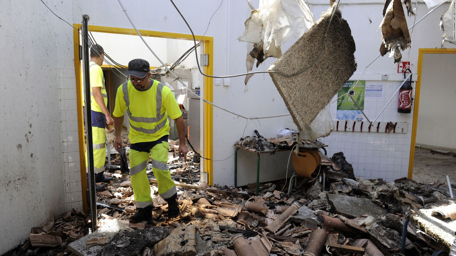 A man walks among the ruins of an elementary school burnt down in Vitrolles, France.