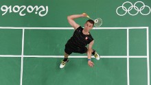 Poland's Adrian Dziolko serves to China's Chen Long during their men's singles qualifying badminton match.