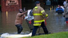 A firefighter helps a resident in Baton Rouge on Friday, August 12.