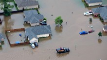 Rescue personnel and civilians team up to pull people from their homes along the Tangipahoa River on August 13.
