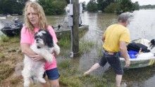 Tammie Wise holds her dog, Mikey, after Jeffrey Lesage helped rescue them in Central, Louisiana, on August 13.