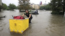A firefighter brings luggage to hotel guests during an evacuation of the Fairfield Inn in Lafayette, Louisiana, on August 13.