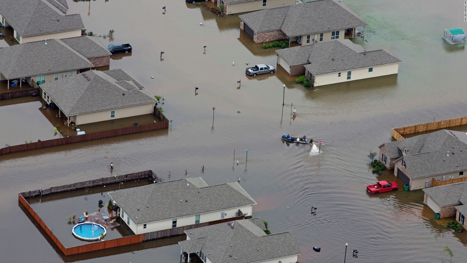 A boat motors between flooded homes after torrential rainfail in Hammond, Louisiana.