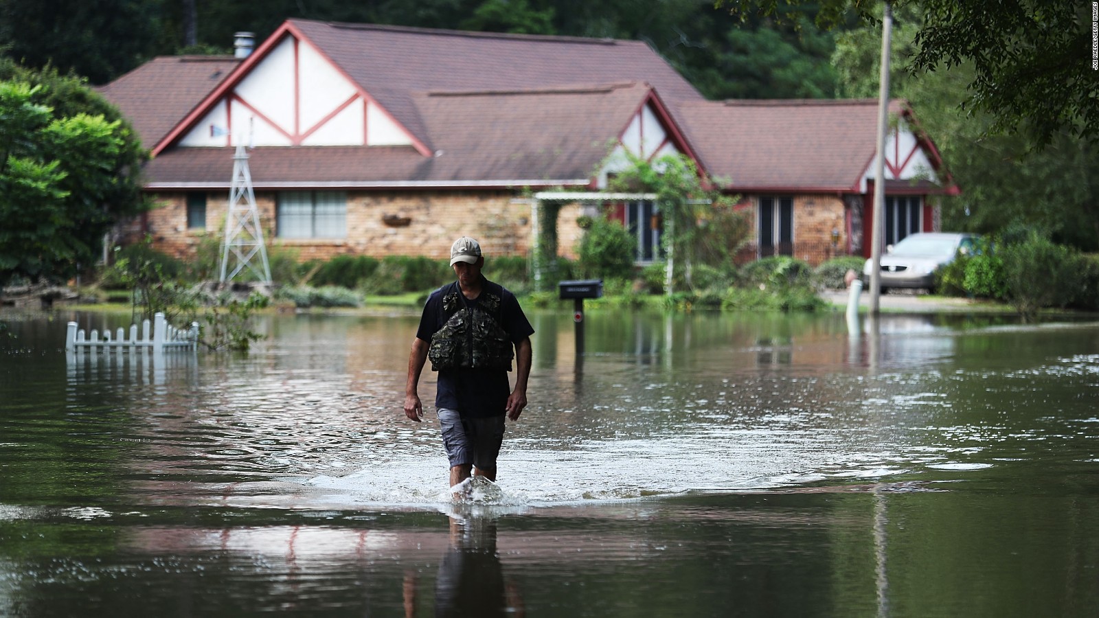 Ryan Evans walks along a flooded road on August 15 in Baton Rouge, Louisiana.
