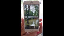 Noel Michael holds up a cell-phone photo of her flooded home in Livingston, Louisiana, on August 15.