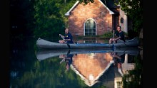 Danny and Alys Messenger canoe away from their flooded home in Prairieville on August 16.