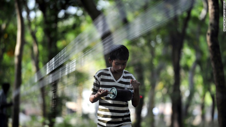 An Indian youth prepares &quot;manja,&quot; a strong string used to fly kites, in Allahabad on April 9, 2013.