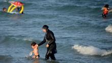 A woman wears a burkini, on a beach near Tunis, Tunisia.
