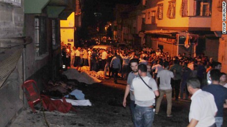 People gather early Sunday at the scene of the explosion in Gaziantep.