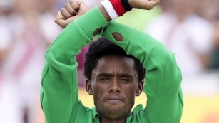 Ethiopian marathoner makes protest sign at finish line