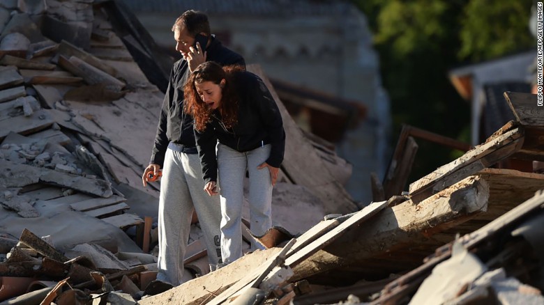 Residents take in the damage in Amatrice.