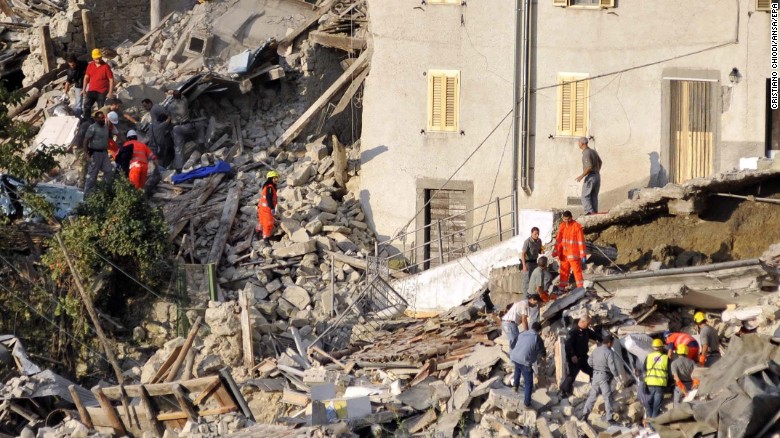 Search and rescue teams survey the rubble of collapsed buildings in Pescara del Tronto.