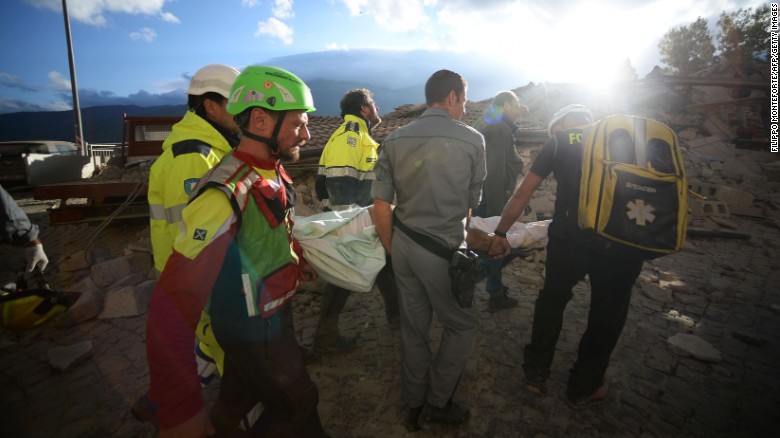 Rescuers carry a man through earthquake debris in Amatrice.