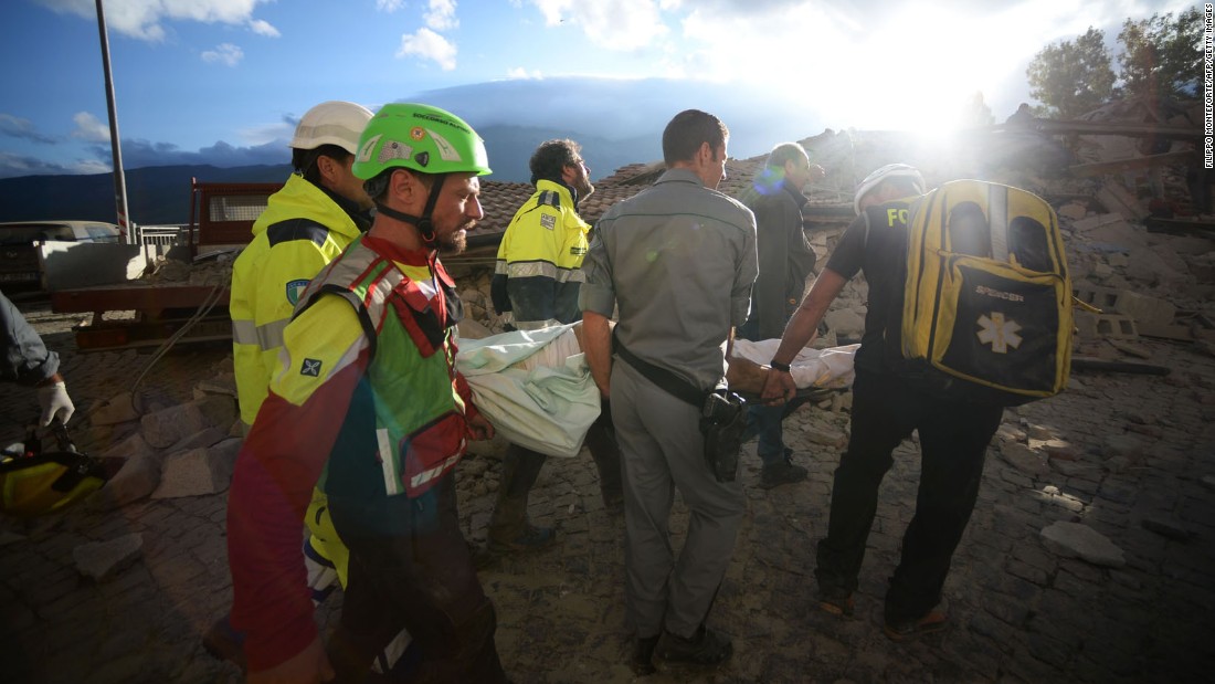 Rescuers carry a man through earthquake debris in Amatrice.