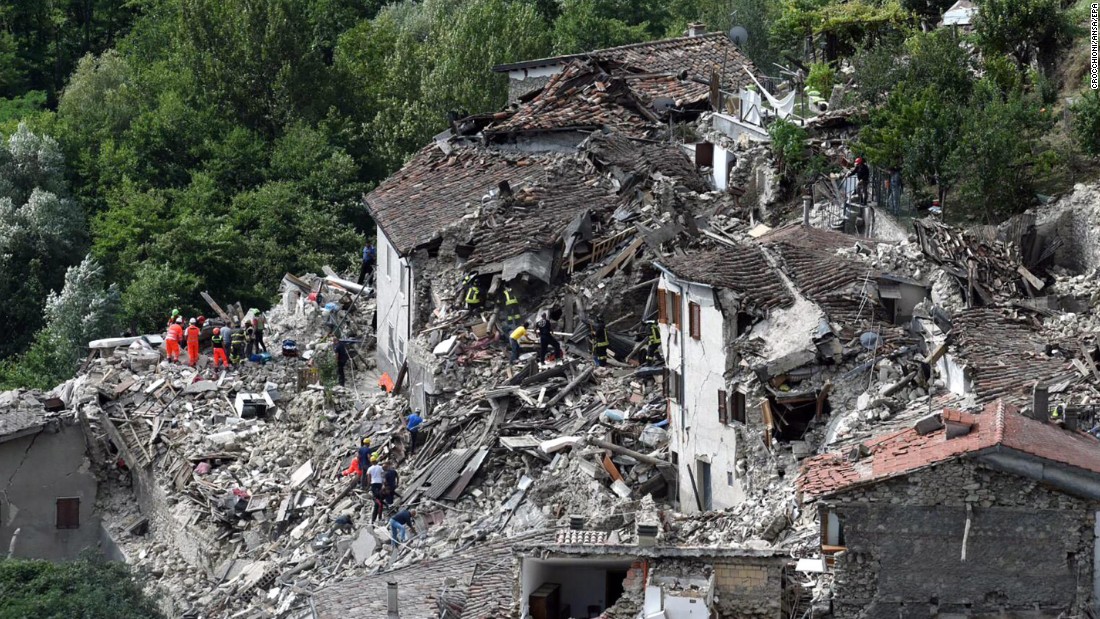 Search-and-rescue teams survey collapsed houses in Pescara del Tronto on August 24.