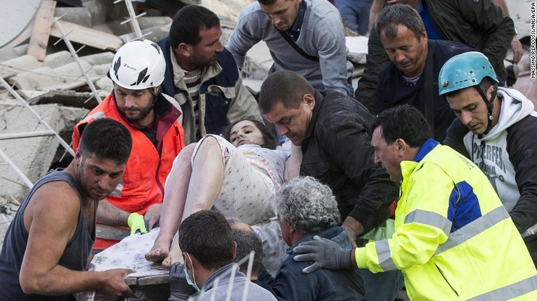 Rescuers help a woman from the rubble in Amatrice, Italy, after a 6.2-magnitude earthquake struck the central part of the country on Wednesday, August 24. Dozens of people have been killed, and the death toll is expected to rise as rescue teams reach remote areas.