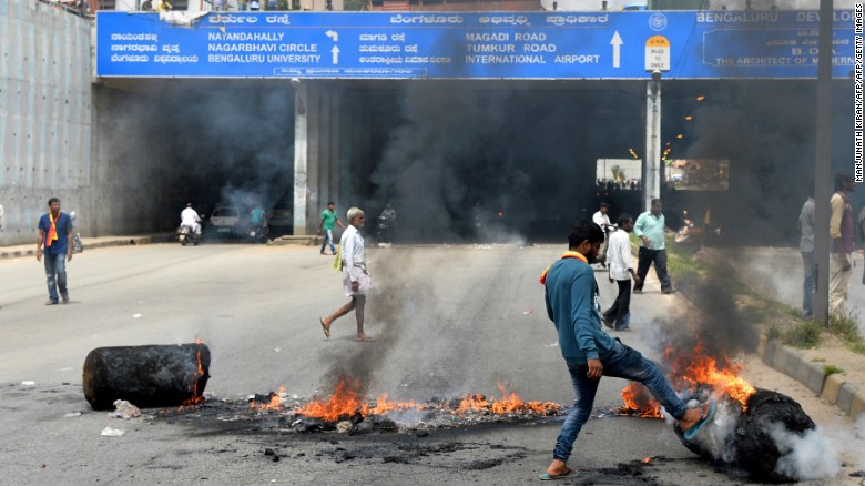 An Indian activist removes a traffic blockade on a major connecting road during a statewide strike in Bangalore on September 9, 2016.