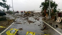 Recovery workers survey storm damage near Fugang in southern Taiwan. 