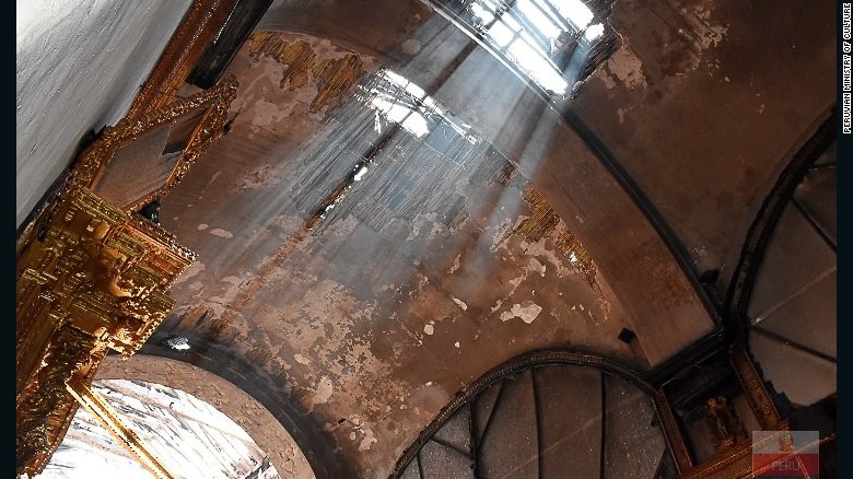 Light beams shine through ceiling damage to the historic Cusco church. 