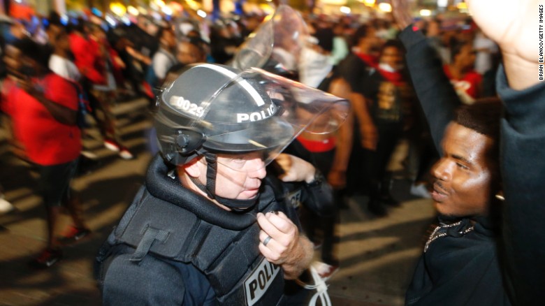 Protesters march in the streets of Charlotte, North Carolina, on the evening of Wednesday, September 21. Violent protests erupted the night before following the death of Keith Lamont Scott, who was shot in an apartment complex parking lot while police tried to serve a warrant for a different man. Charlotte-Mecklenburg Police Chief Kerr Putney said Scott exited his car with a gun and that he was shot after he wouldn&#39;t drop it. Scott&#39;s family said he was unarmed and sitting in his car reading a book.