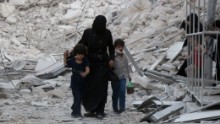 A Syrian family leaves the area following a reported airstrike on Friday, September 23, in rebel-held east Aleppo. Following the airstrike, recovery teams from Syria Civil Defense, known as the White Helmets, began working to free the trapped and recover the dead, including small children.