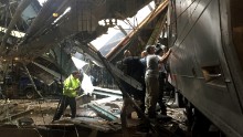Emergency workers and others survey the train after the crash.