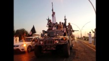 ISIS fighters parade down a main road in a commandeered Iraqi security forces vehicle after the militant group took control of Mosul in June 2014.