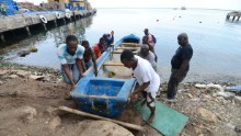 Fishermen pull a boat out of the water in Kingston on Saturday.
