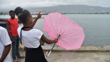 A girl's umbrella is turned inside out by the wind Monday in Cite Soleil, near the Haitian capital of Port-au-Prince.
